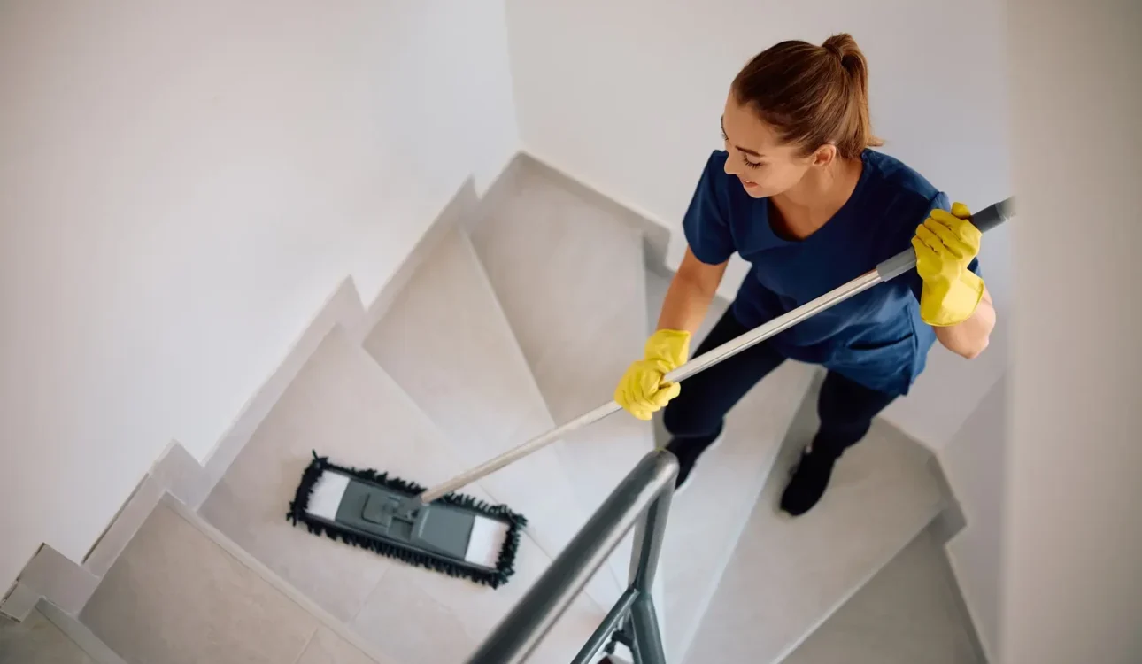 Above view of housekeeper cleaning the stairs with a mop.